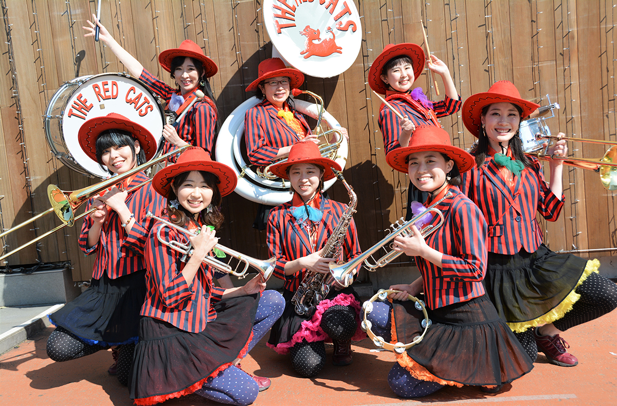 the red catsメンバー写真。金管楽器を構えてお揃いの衣装
